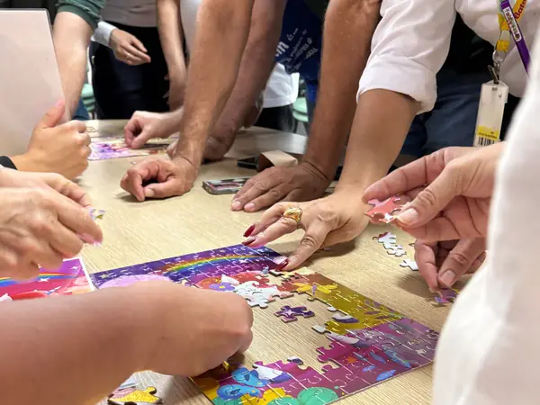 Equipe montando um quebra-cabeça colorido em conjunto